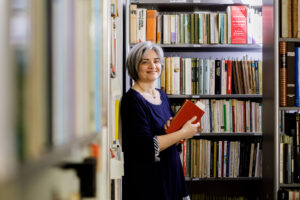 Loredana Gasparri in biblioteca in mezzo ai libri da scegliere